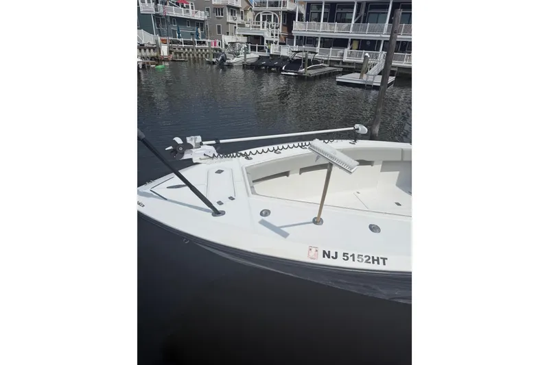 Slide: The Image of 2006 SeaVee 340B boat docked, featuring a clean white deck and visible registration number. - 9