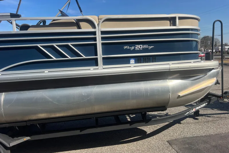 Slide: The Image of 2023 Sun Tracker Party Barge 20 DLX pontoon boat on trailer, side view. - 10