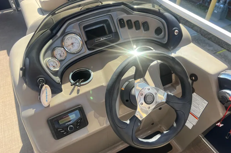 Slide: The Image of 2023 Sun Tracker Party Barge 20 DLX dashboard with steering wheel and controls. - 15