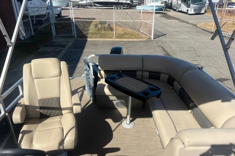 Slide: The Image of 2023 Sun Tracker Party Barge 20 DLX interior with beige seating and table. - 24