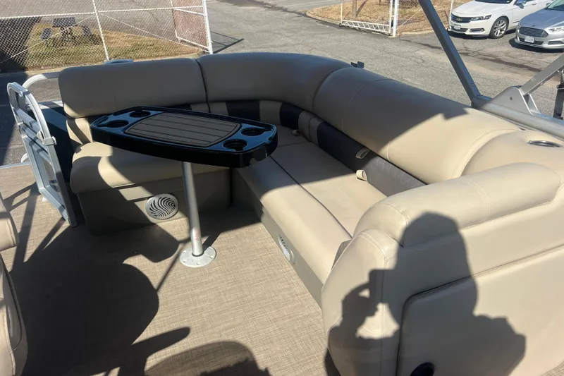 Slide: The Image of 2023 Sun Tracker Party Barge 20 DLX interior with beige seating and table. - 25