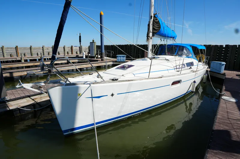 Slide: The Image of 2009 Jeanneau Sun Odyssey 36i sailboat docked in a marina under clear blue skies. - 10