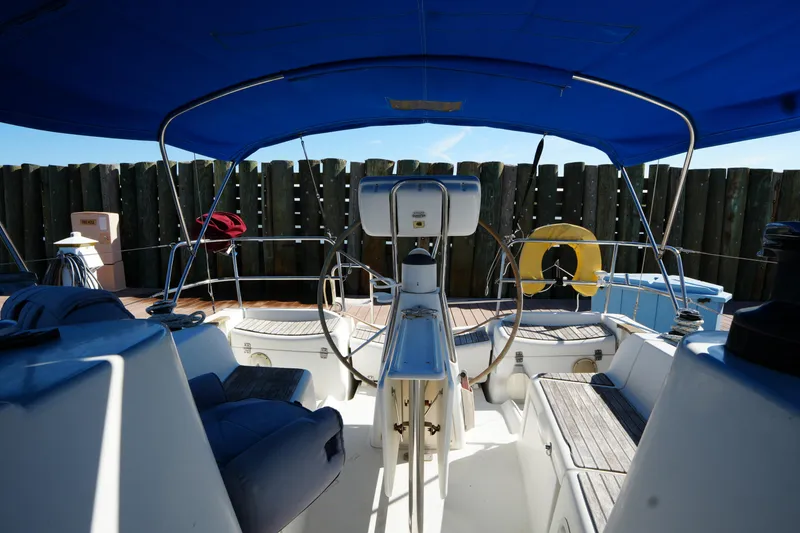 Slide: The Image of Cockpit of 2009 Jeanneau Sun Odyssey 36i sailboat with blue canopy and wooden seating. - 16