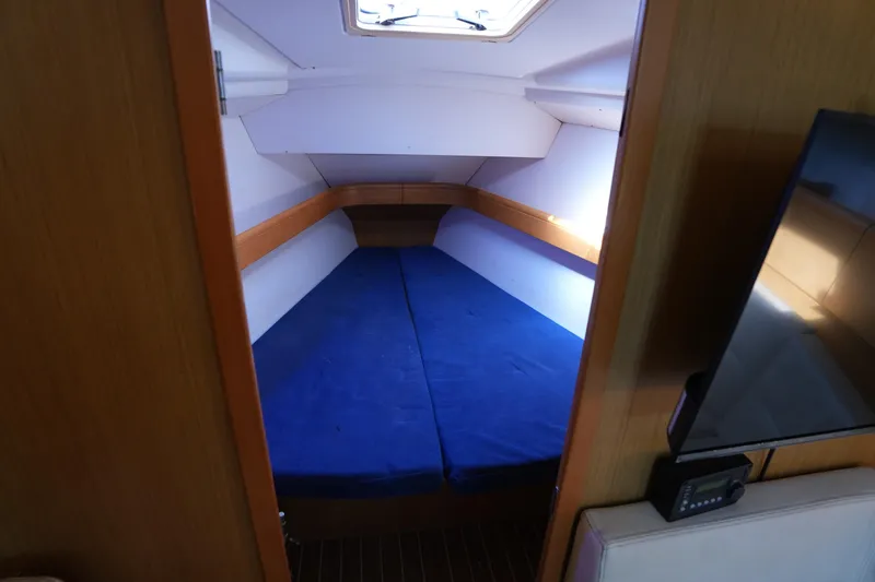 Slide: The Image of 2009 Jeanneau Sun Odyssey 36i cabin with blue bedding and wooden interior. - 18