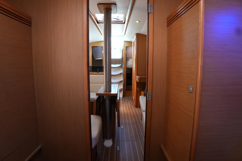 Slide: The Image of Interior of 2009 Jeanneau Sun Odyssey 36i sailboat, featuring wood paneling and seating. - 19