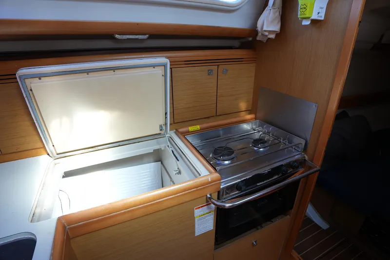 Slide: The Image of 2009 Jeanneau Sun Odyssey 36i yacht kitchen with stove and open fridge. - 24