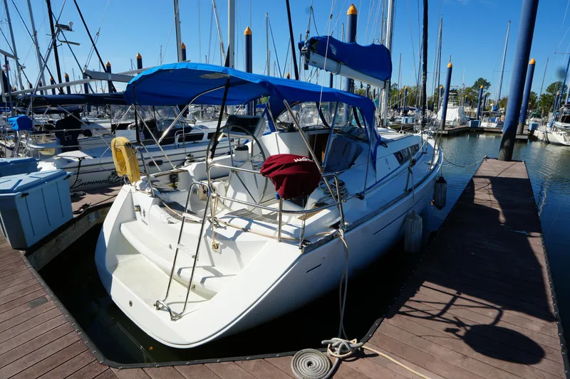 Slide: The Image of 2009 Jeanneau Sun Odyssey 36i sailboat docked at marina with blue canopy. - 7