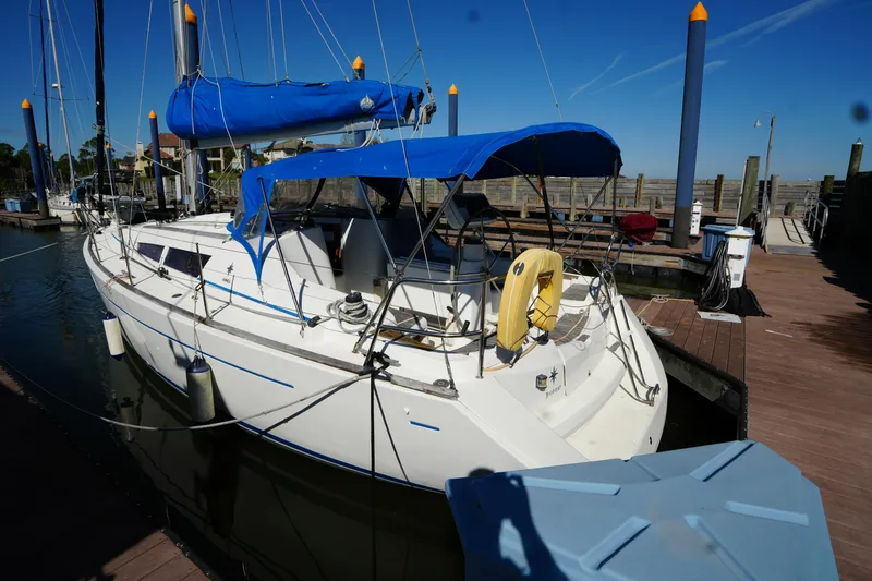 Slide: The Image of 2009 Jeanneau Sun Odyssey 36i sailboat docked with blue canopy and lifebuoy. - 9