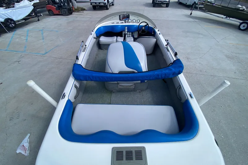 Slide: The Image of 1997 Malibu Tantrum boat interior with blue and white seating, parked on concrete. - 11