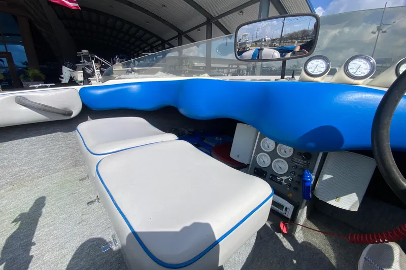 Slide: The Image of Interior of a 1997 Malibu Tantrum boat with blue and gray seating, dashboard gauges. - 16