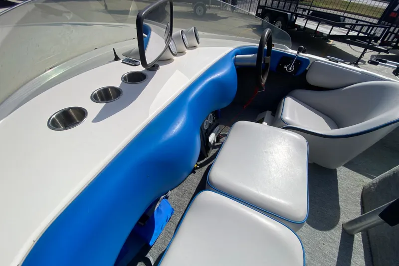 Slide: The Image of 1997 Malibu Tantrum boat interior with blue and white seating and cup holders. - 17