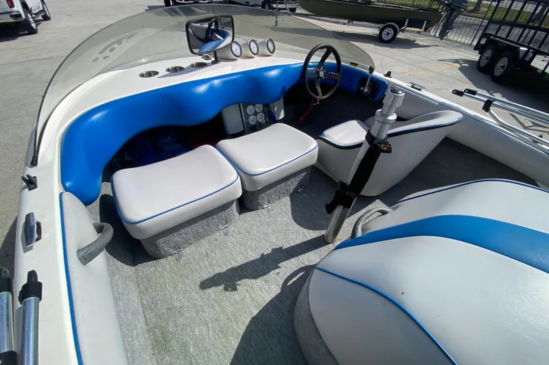 Slide: The Image of 1997 Malibu Tantrum boat interior with blue and white seating and steering wheel. - 19