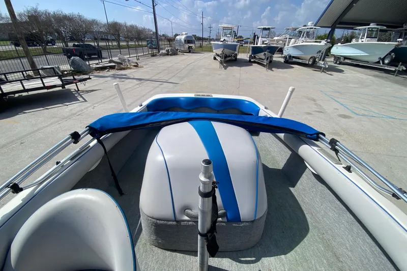 Slide: The Image of 1997 Malibu Tantrum boat interior with blue and white seating, parked outdoors. - 20