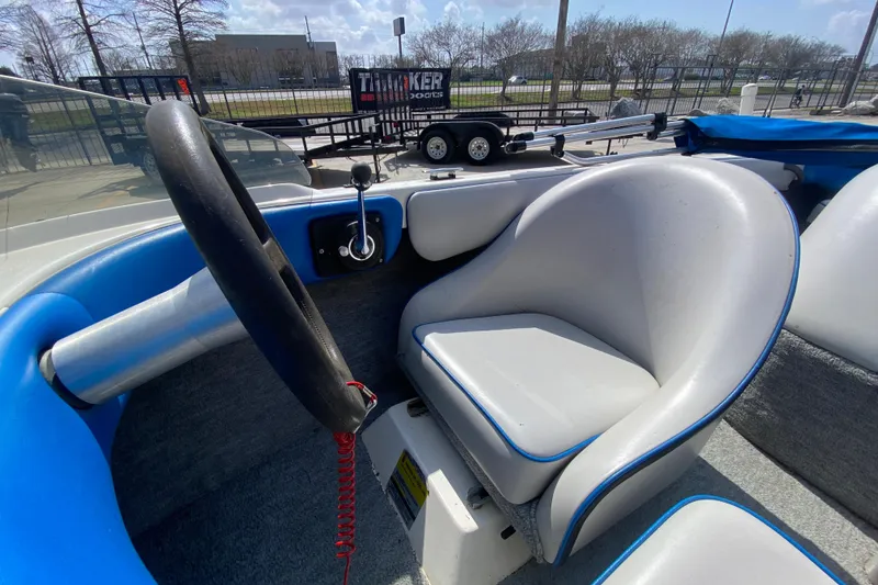 Slide: The Image of 1997 Malibu Tantrum boat interior with steering wheel and seat, parked near a trailer. - 22
