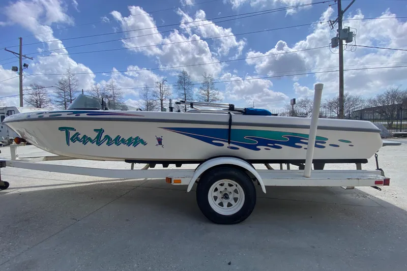 Slide: The Image of 1997 Malibu Tantrum boat on trailer under a bright blue sky. - 7