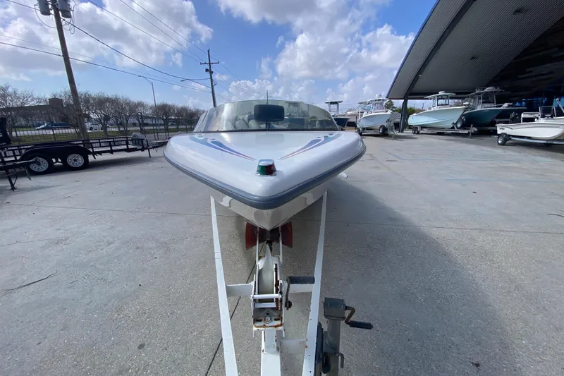 Slide: The Image of 1997 Malibu Tantrum boat on trailer, parked outdoors under a cloudy sky. - 9