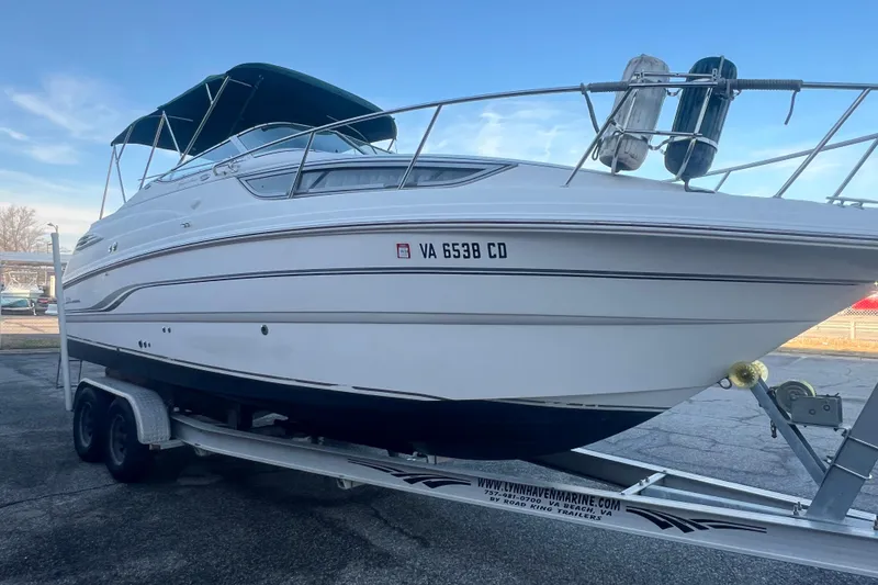 Slide: The Image of 2001 Chaparral Signature 260 boat on trailer, white hull, blue canopy, parked outdoors. - 10