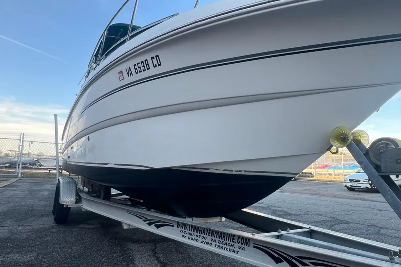 Slide: The Image of 2001 Chaparral Signature 260 boat on trailer, parked outdoors under clear sky. - 11
