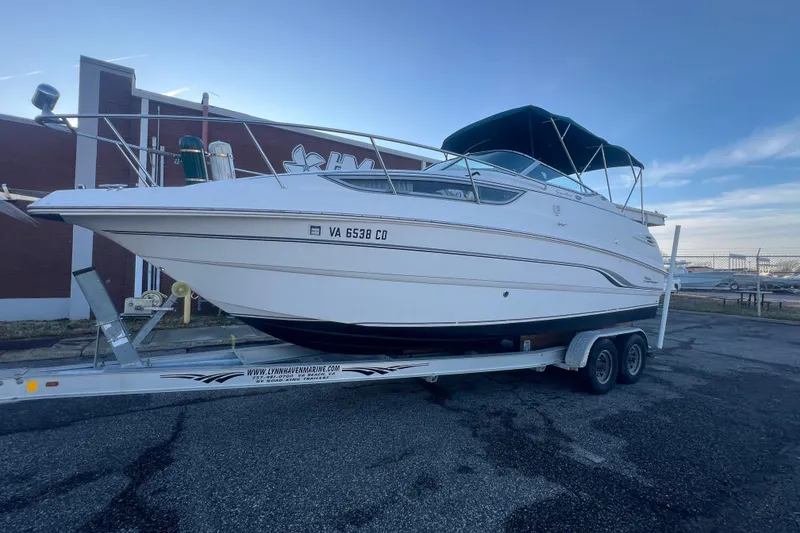 Slide: The Image of 2001 Chaparral Signature 260 boat on trailer, parked outdoors with blue sky background. - 43