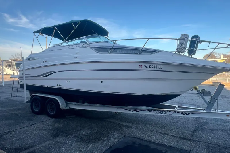 Slide: The Image of 2001 Chaparral Signature 260 boat on trailer, parked outdoors under clear sky. - 9