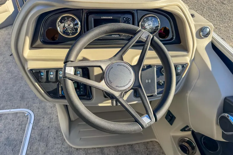 Slide: The Image of Steering wheel and dashboard of 2025 Berkshire 22CL LE boat, featuring modern controls. - 9