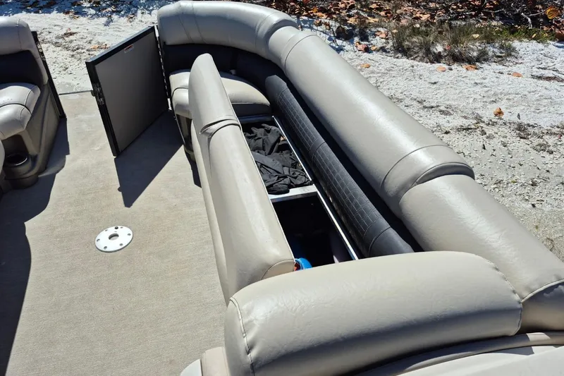 Slide: The Image of 2017 Avalon 2785 boat interior with open storage compartment and beige seating. - 21