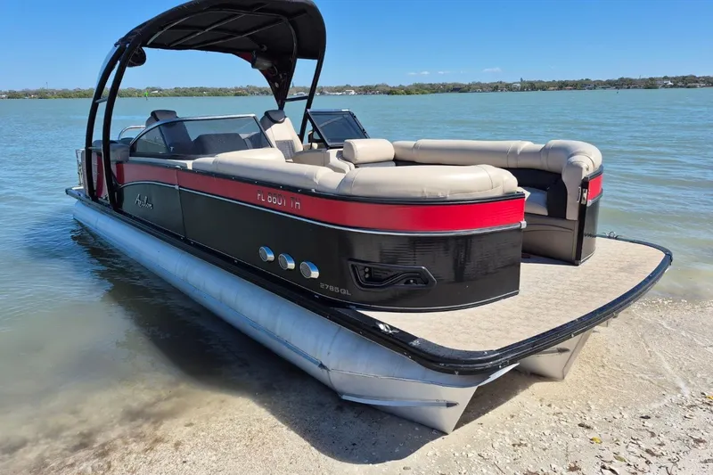 Slide: The Image of 2017 Avalon 2785 pontoon boat docked on a serene lake shore. - 3