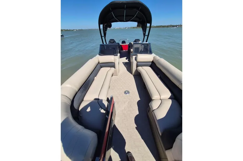 Slide: The Image of 2017 Avalon 2785 pontoon boat interior with beige seating on a sunny day. - 5