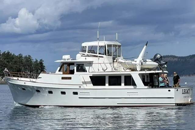 The Image of 1981 Ocean Alexander 50 Pilothouse yacht cruising on a calm sea under cloudy skies. - 0