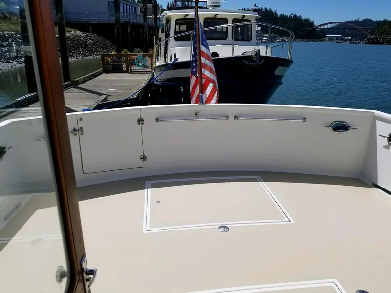 Slide: The Image of 1981 Ocean Alexander 50 Pilothouse yacht docked with flag. - 19