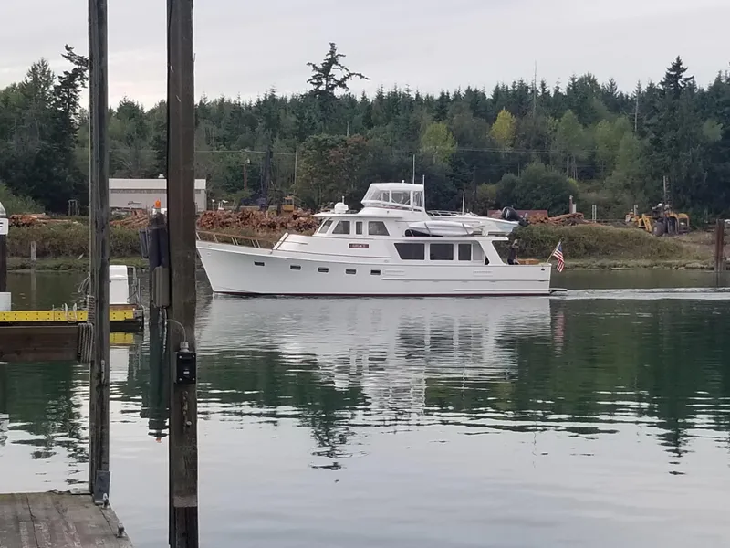 Slide: The Image of 1981 Ocean Alexander 50 Pilothouse on calm water with forest backdrop. - 3