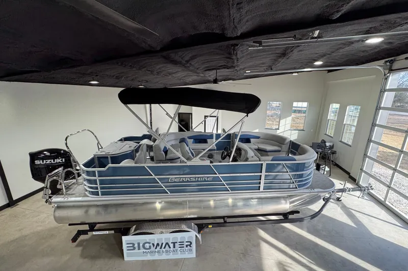 Slide: The Image of 2025 Berkshire 22RFC LE pontoon boat in showroom with Suzuki outboard motor. - 3