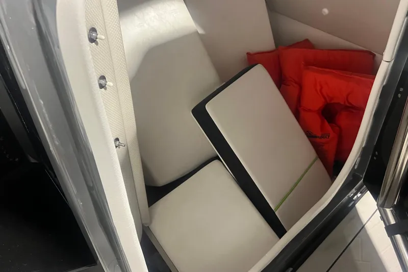 Slide: The Image of Interior storage of 2021 Yamaha Boats 255XD with life jackets and cushions. - 25