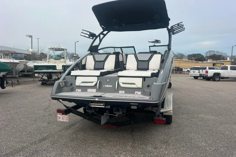 Slide: The Image of 2021 Yamaha Boats 255XD, rear view, parked on trailer in a marina lot. - 4