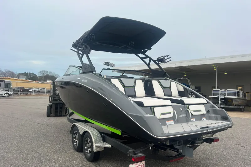 Slide: The Image of 2021 Yamaha Boats 255XD, sleek gray design, dual-axle trailer, outdoor display. - 5