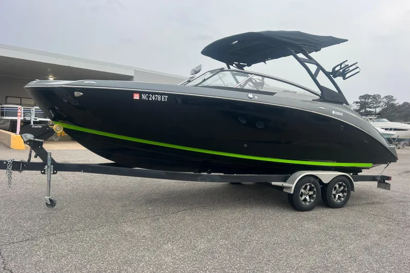 Slide: The Image of 2021 Yamaha Boats 255XD on trailer, sleek black design with green accent stripe. - 7