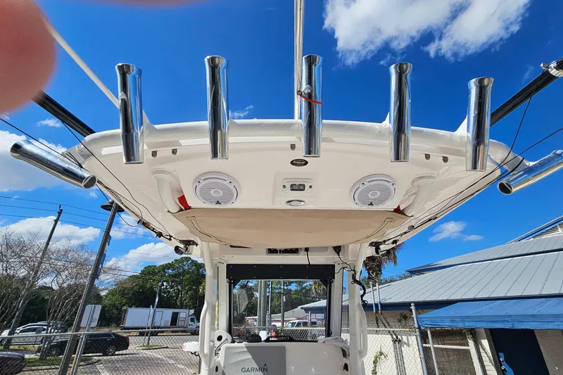 Slide: The Image of 2015 Everglades 255 Center Console boat with rod holders and speakers under a clear blue sky. - 23