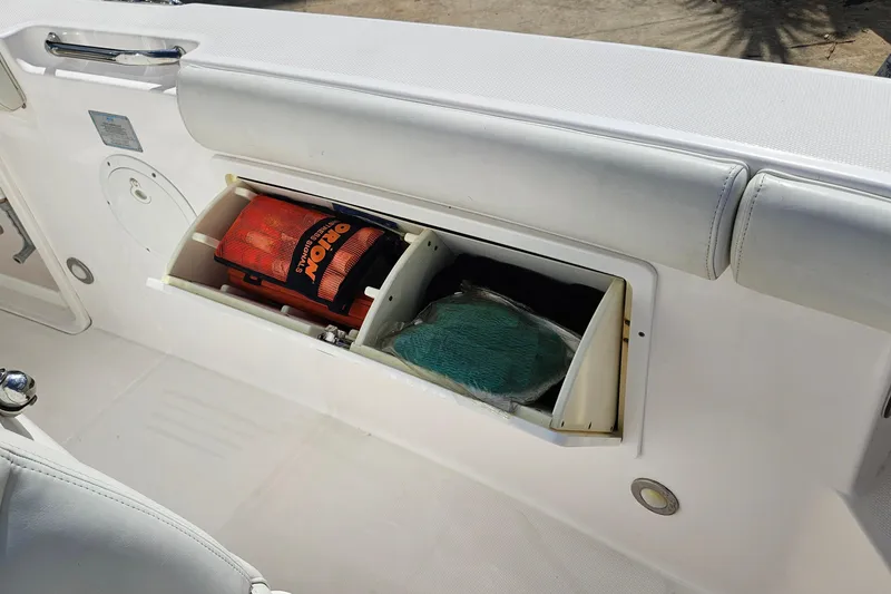 Slide: The Image of Storage compartment on a 2015 Everglades 255 Center Console boat, containing safety gear. - 34