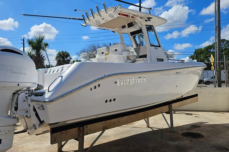 Slide: The Image of 2015 Everglades 255 Center Console boat with Yamaha engine, displayed outdoors under blue sky. - 4