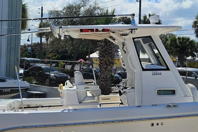 Slide: The Image of 2015 Everglades 255 Center Console boat docked, featuring fishing rods and seating. - 5