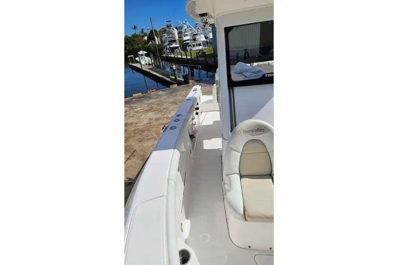 Slide: The Image of 2015 Everglades 255 Center Console boat docked at marina, showcasing seating and deck. - 8