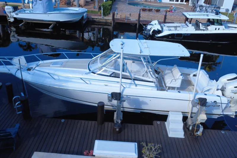 Slide: The Image of 2005 Intrepid 348 Walkaround boat docked at a marina, featuring sleek design and spacious deck. - 10