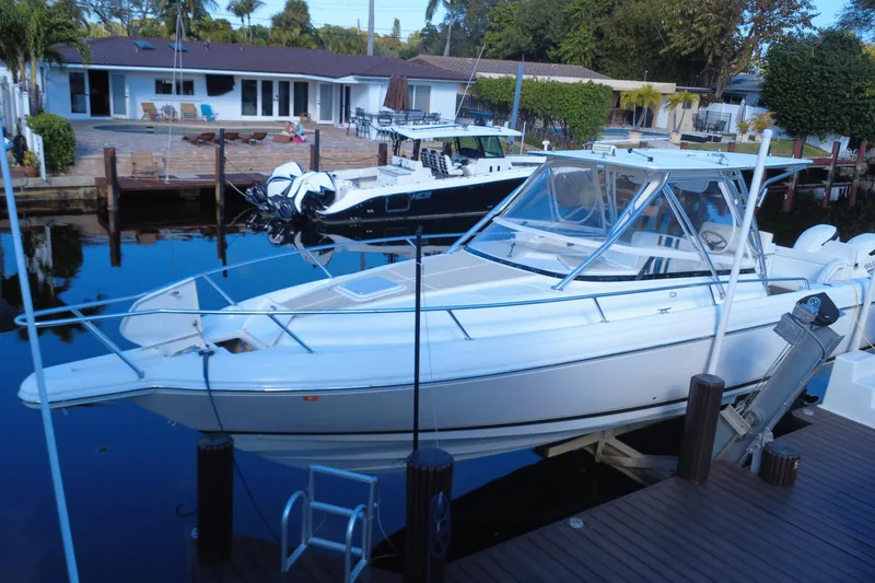 Slide: The Image of 2005 Intrepid 348 Walkaround boat docked near waterfront homes. - 12