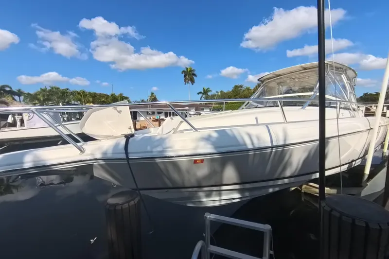 Slide: The Image of 2005 Intrepid 348 Walkaround boat docked under a clear blue sky. - 15