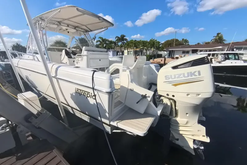 Slide: The Image of 2005 Intrepid 348 Walkaround boat with Suzuki outboard motor docked under clear skies. - 17