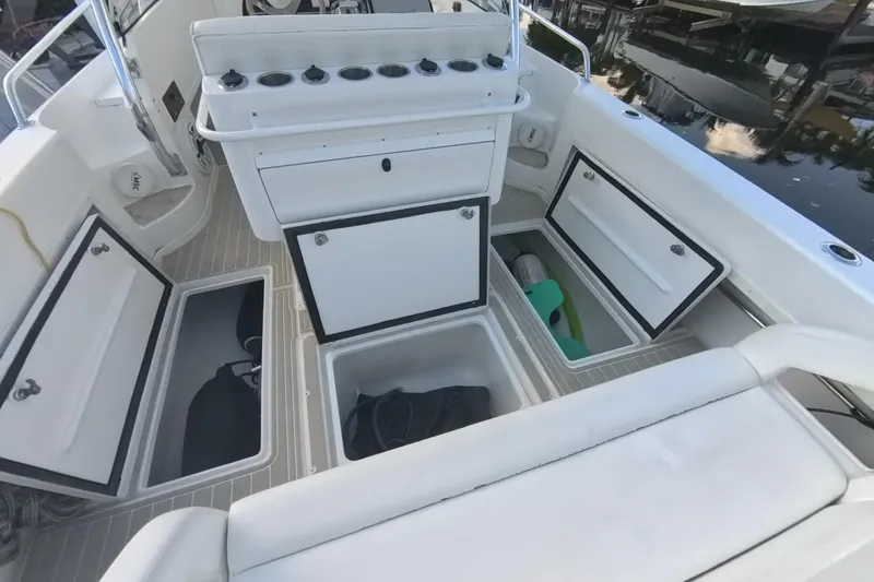 Slide: The Image of 2005 Intrepid 348 Walkaround boat interior with open storage compartments and seating. - 29