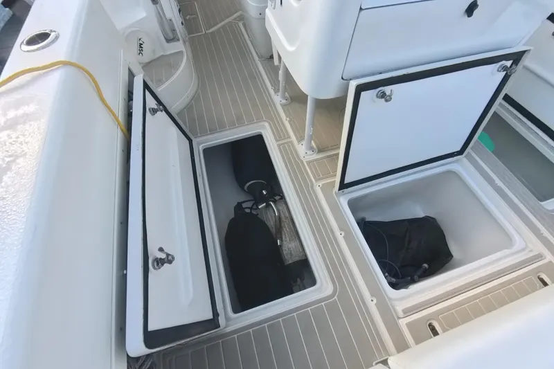 Slide: The Image of 2005 Intrepid 348 Walkaround boat deck with open storage compartments. - 30