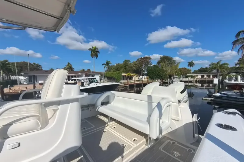 Slide: The Image of 2005 Intrepid 348 Walkaround boat docked, featuring white seating and clear blue skies. - 32