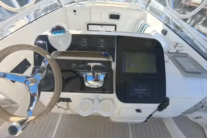 Slide: The Image of 2005 Intrepid 348 Walkaround boat helm with steering wheel and navigation controls. - 37