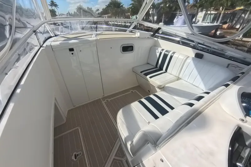 Slide: The Image of 2005 Intrepid 348 Walkaround boat interior with white seating and striped cushions. - 41